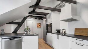 Una cocina moderna con lavavajillas, electrodomésticos de acero inoxidable y encimera de madera.