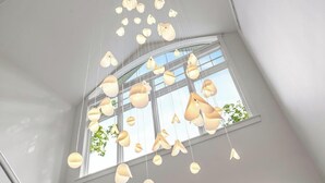 Une pièce dotée d’une grande fenêtre et de plusieurs luminaires suspendus.