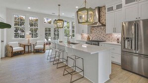 A spacious kitchen with a large island, white cabinetry, and stainless steel appliances. - Newly Remodeled | Watercolor Resort | Golf Cart! (Santa Rosa Beach)