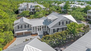 A residential area with multiple houses, featuring a mix of architectural styles, surrounded by lush greenery. - Newly Remodeled | Watercolor Resort | Golf Cart! (Santa Rosa Beach)