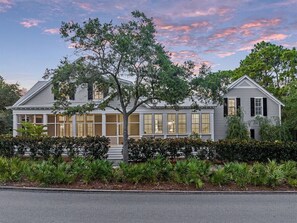 A two-story house with a covered porch, large windows, and a well-maintained garden.