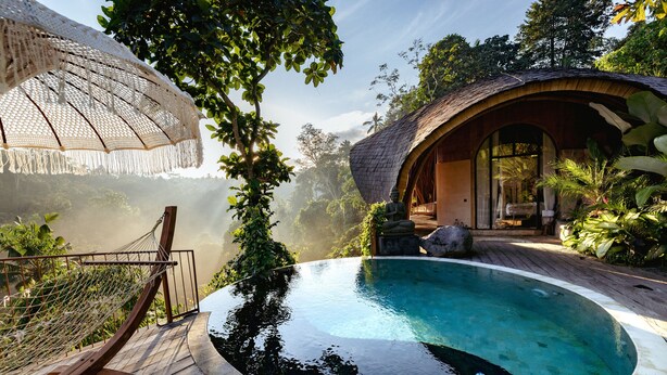 A wooden deck with a pool, surrounded by lush greenery and a thatched-roof structure. - Belalu Bali Boutique & Spa Experience (Ubud)