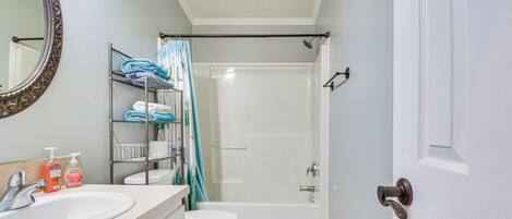 Un baño con lavamanos, inodoro y ducha.
