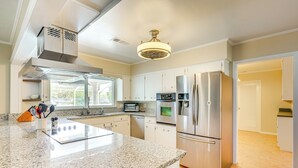 A modern kitchen with granite countertops, stainless steel appliances, and a large island.
