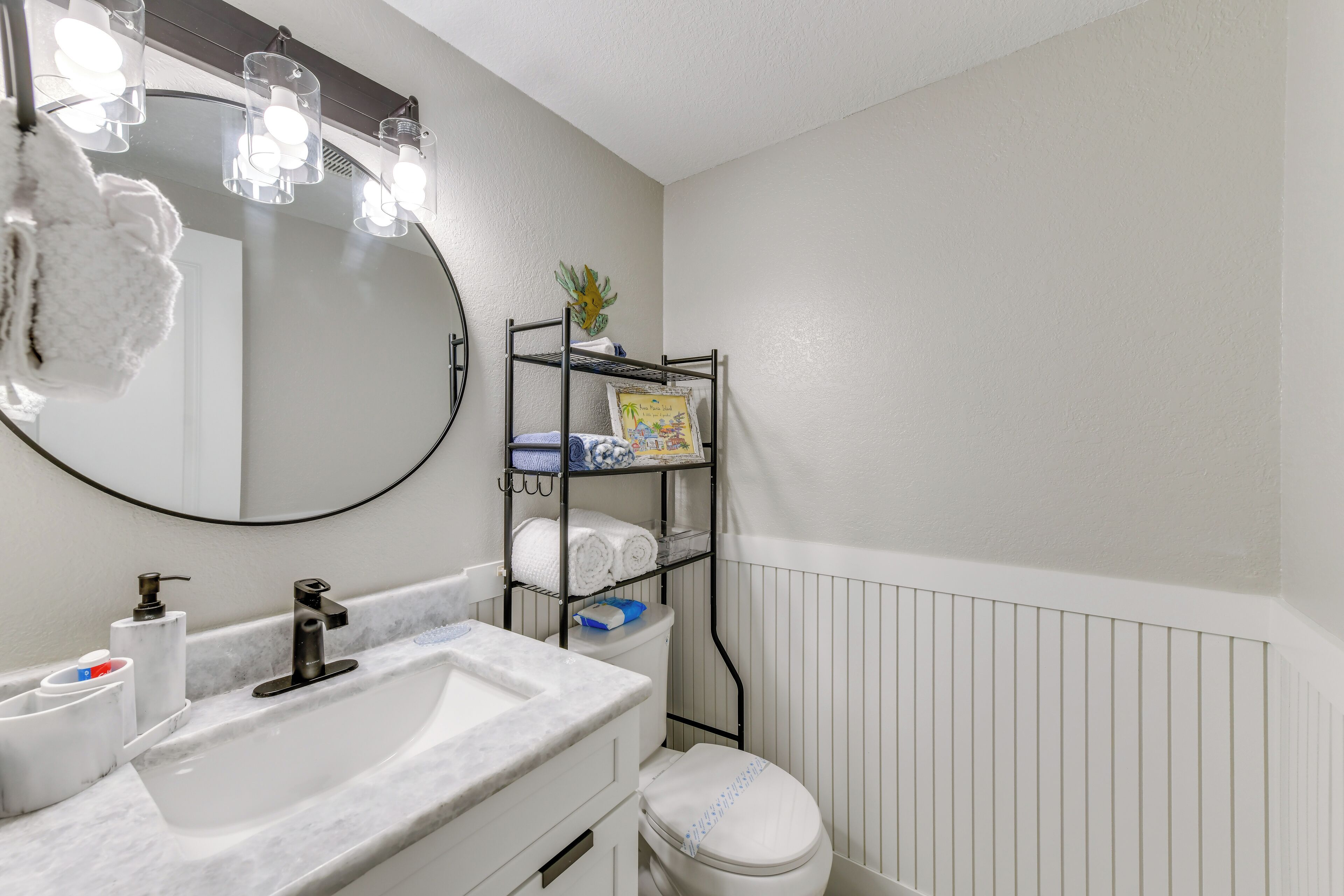 A bathroom with a white sink, a mirror, and a towel rack.