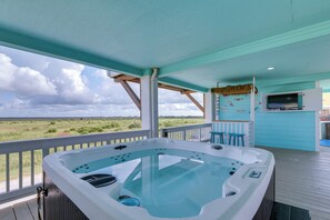 A hot tub on a deck with a view of the landscape.