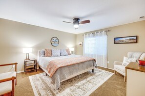 A bedroom with a bed, bedside tables, a chair, a ceiling fan, and a window with curtains. - Mtn-view Paradise Near Usafa in Colorado Springs! (Colorado Springs)