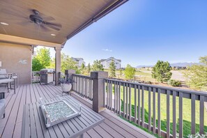 A wooden deck with a glass table, outdoor furniture, and a view of a residential area with houses and trees. - Mtn-view Paradise Near Usafa in Colorado Springs! (Colorado Springs)