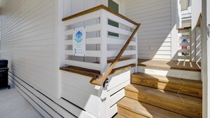 A wooden staircase with a white railing leading to an upper level. - 1 Mi to Beach: Home w/ Pool Access in Port Aransas (Port Aransas)