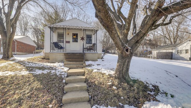 A small white house with a porch, steps leading to the entrance, and a star decoration on the door. - 3 Mi to Englewood Dam: Pet-friendly Home w/ Yard! (Englewood)