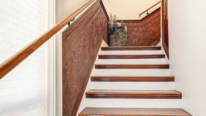 Una escalera de madera con escalones blancos y una barandilla decorativa.