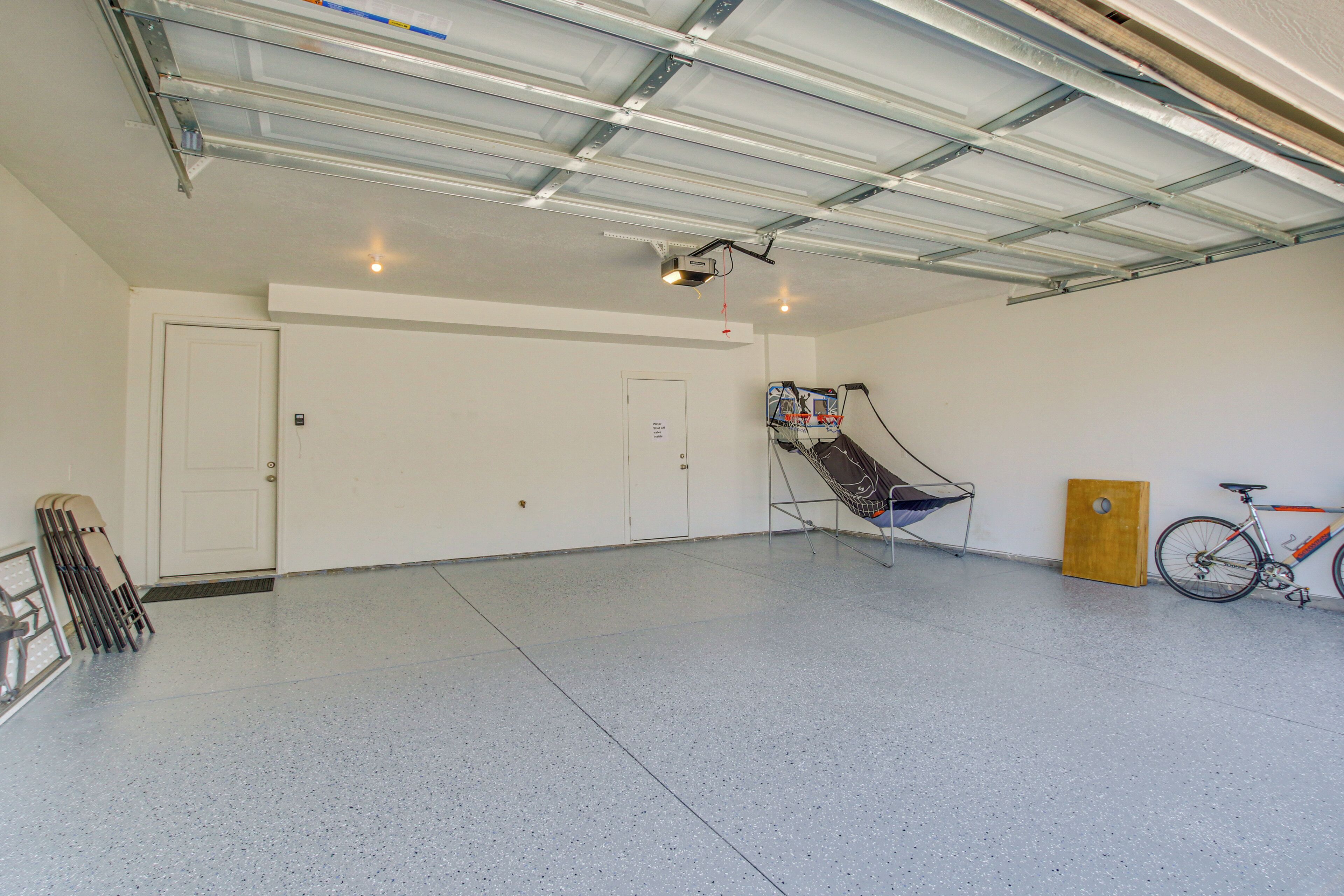 A spacious garage with a ceiling fan, a projector, and a bicycle.