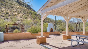A covered outdoor area with a picnic table and a water fountain.