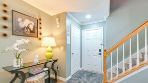 A hallway with a console table, a lamp, a framed picture, and a door. - Home 9 Mi to Uptown Charlotte: Dogs Welcome! (Charlotte)