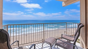 Un balcon avec vue sur la plage et l’océan.
