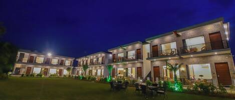 Un hotel moderno con varios pisos, balcones y zonas de estar al aire libre.