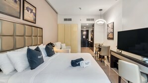 Une chambre d’hôtel comprenant un lit, un bureau, une télévision et un coin repas.