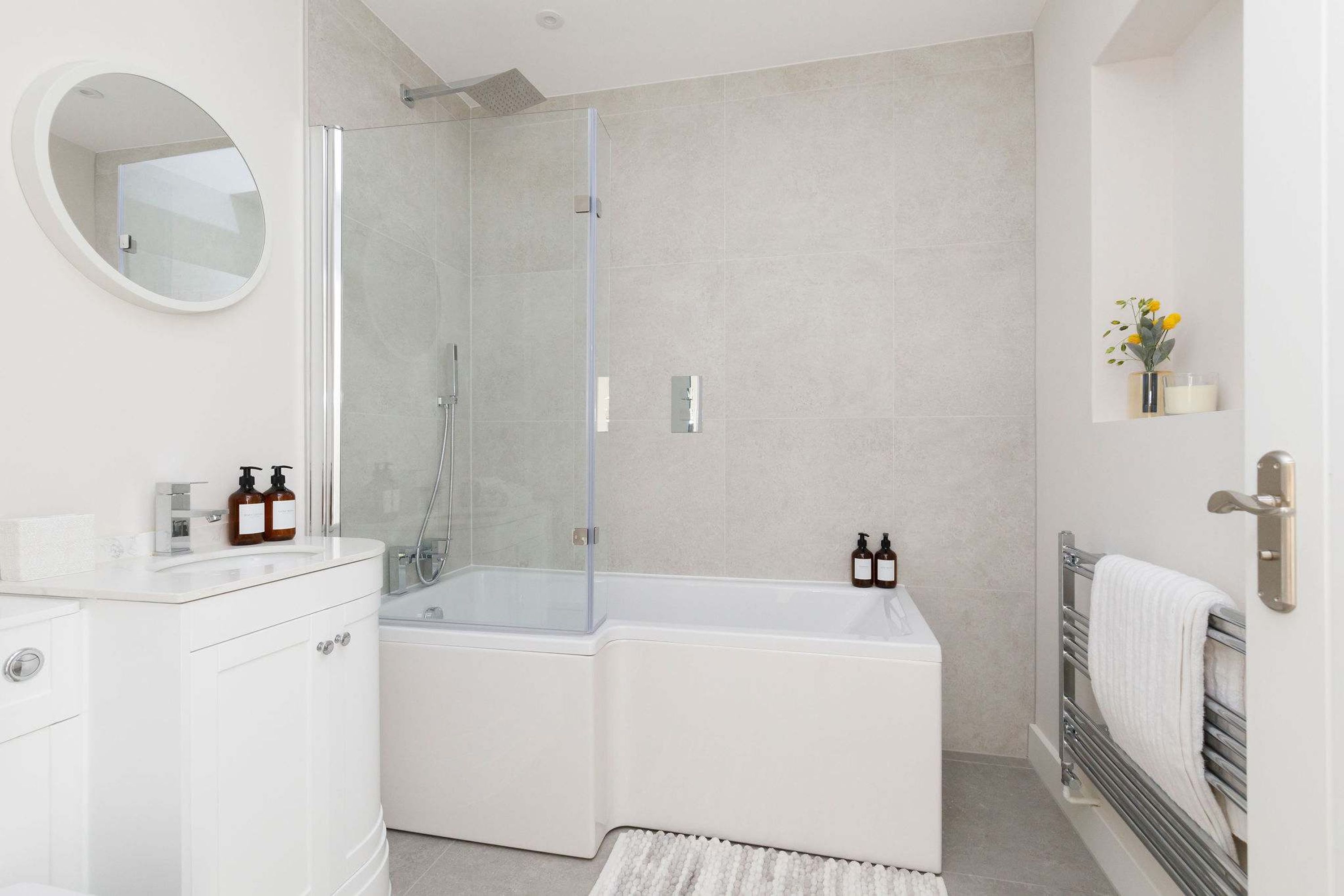 Une salle de bain moderne avec une douche à parois de verre, un meuble-lavabo blanc et une baignoire.
