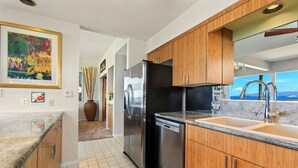 Una cocina moderna con armarios de madera, electrodomésticos de acero inoxidable y un amplio ventanal con vistas.