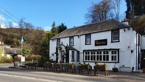 A white building with a sign reading "The Beinn Inn" and outdoor seating with planters. - Bein Inn hotel  (Perth)