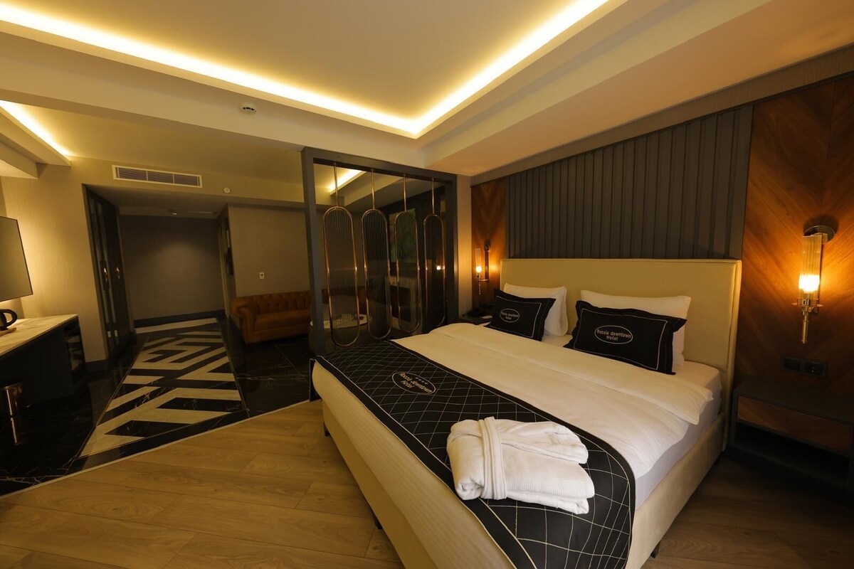 Quarto de hotel moderno com uma cama grande, uma escrivaninha e um espelho.