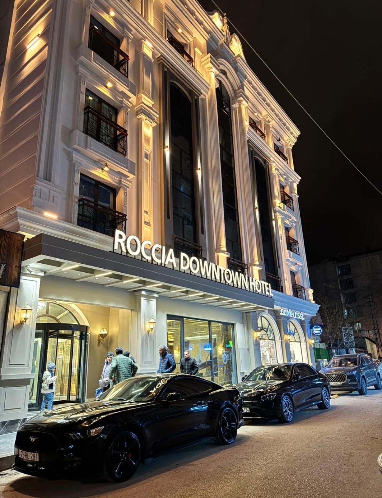 Hotel Roccia Downtown con fachada clásica, amplias ventanas y una entrada destacada.