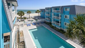 A hotel with a pool, beach view, and multiple balconies. - Oceanfront 2 BR Condo with a Shared Pool! Beach House 302 (Garden City)