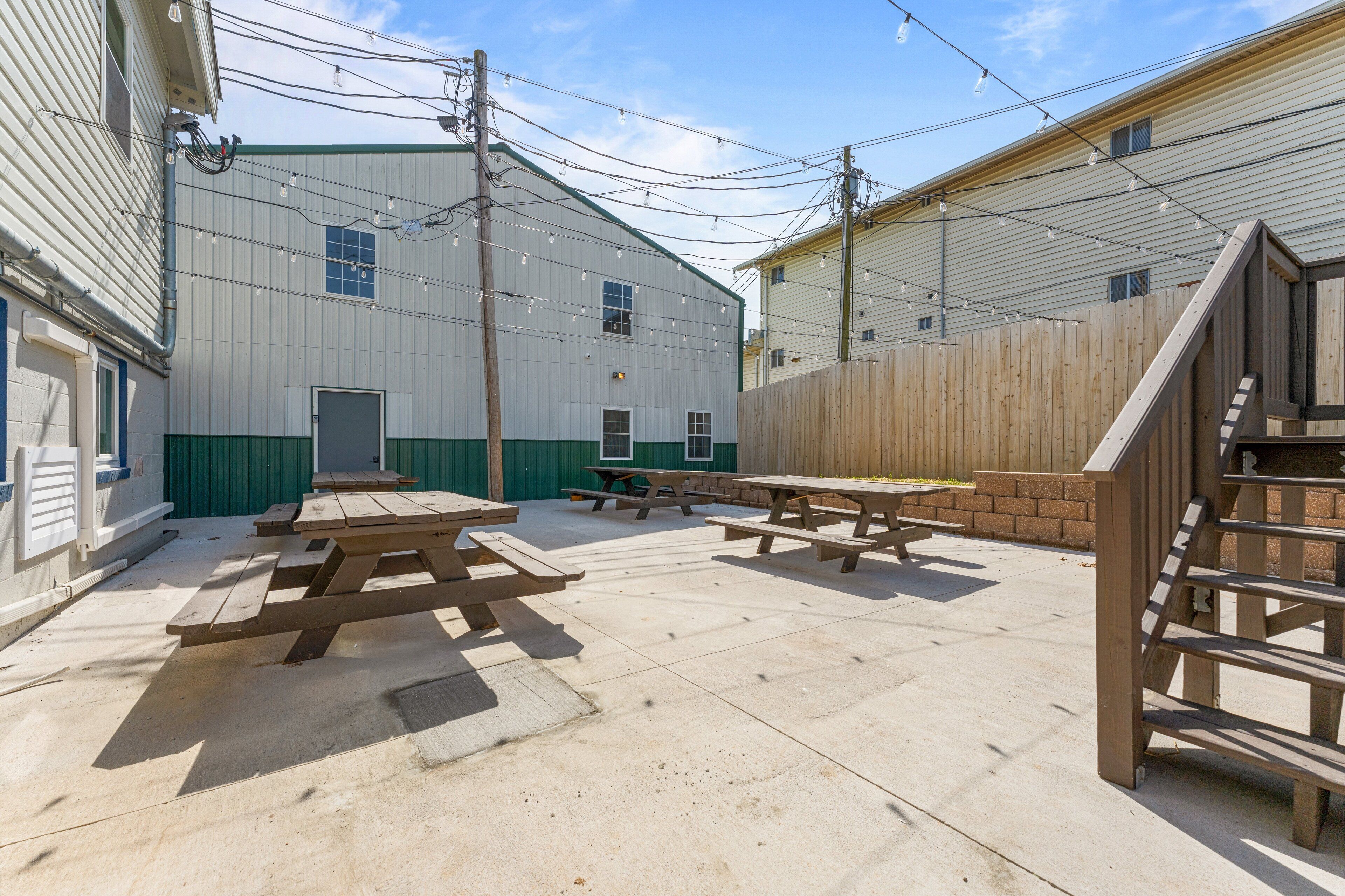 A courtyard with picnic tables and a wooden fence.