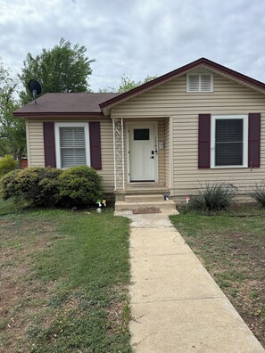 A single-story house with a front door, a mailbox, and a small front yard.