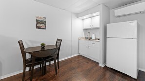 A kitchen with white cabinets, a white refrigerator, and a dining table with chairs. - Sc8- Silver Cove 8 1 Bedroom Condo (Branson)