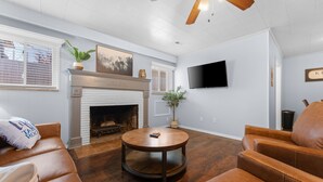 A living room with a fireplace, leather sofas, a round coffee table, and a ceiling fan. - Sc3- Silver Cove 3 3 Bedroom Condo (Branson)