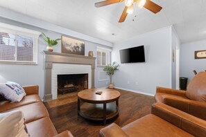 A living room with a fireplace, leather sofas, a round coffee table, and a ceiling fan. - Sc3- Silver Cove 3 3 Bedroom Condo (Branson)