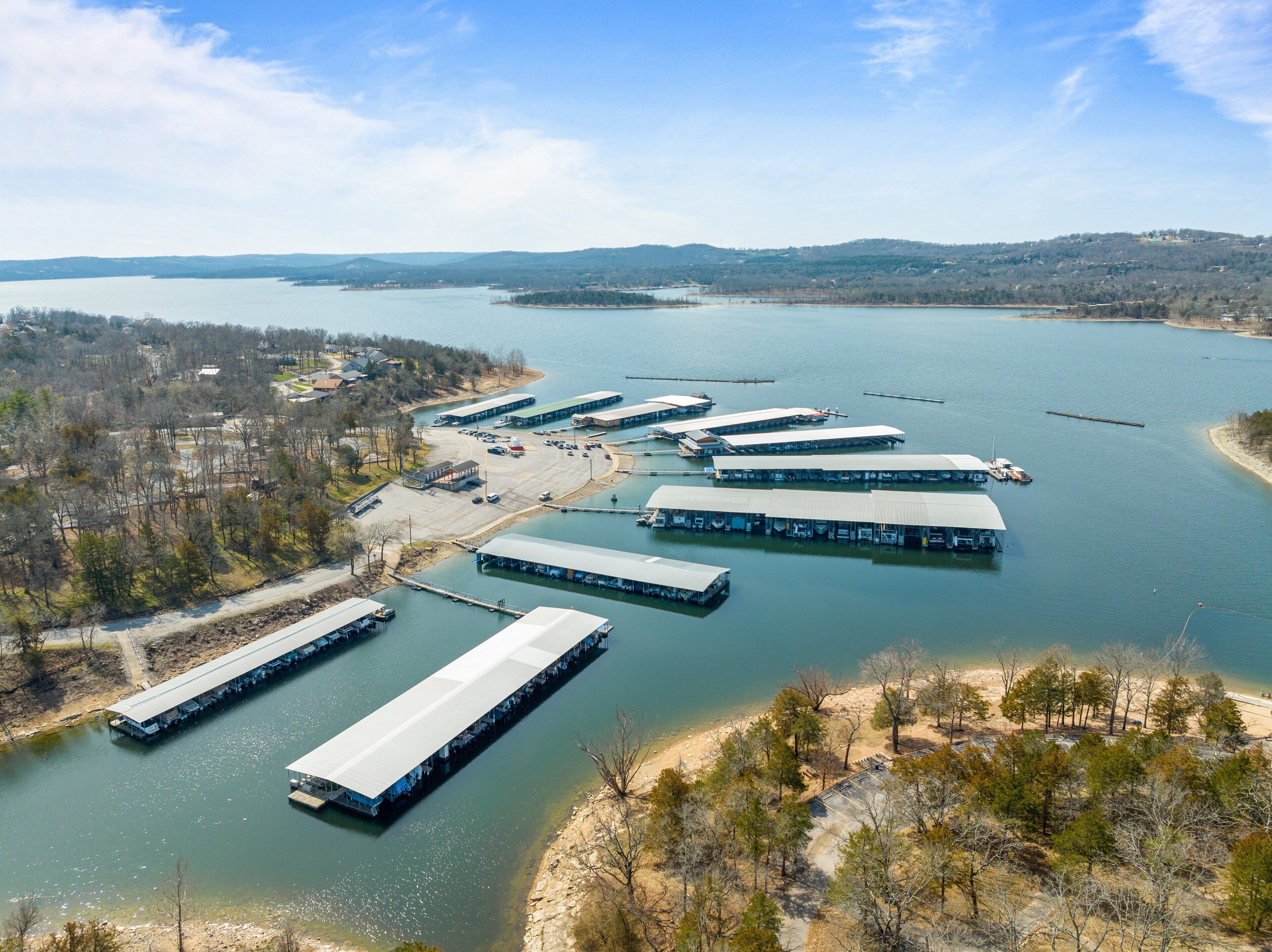 An aerial view of a marina with several docked boats and a sandy beach area.