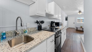 A kitchen with white cabinets, a stainless steel sink, and a granite countertop. - Sc2- Silver Cove 2 2 Bedroom Condo (Branson)