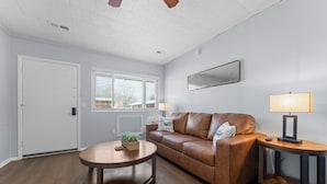 A living room with a brown leather sofa, a round wooden coffee table, and a side table with a lamp. - Sc2- Silver Cove 2 2 Bedroom Condo (Branson)