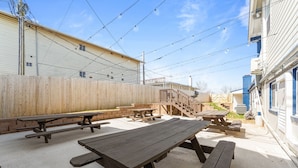An outdoor patio area with picnic tables and a wooden fence. - Sc13- Silver Cove 13 1 Bedroom Condo (Branson)
