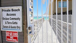 A gated entrance to a private beach area with signs indicating access is restricted to owners and guests only. - Serenity Now-Free Golf Cart-Hot Tub-Comm Pool (Destin)