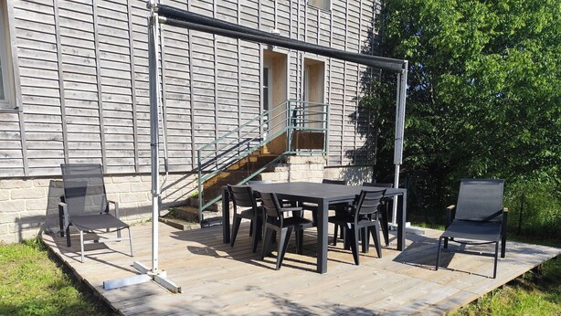 An outdoor patio with a table and chairs, a covered seating area, and a staircase leading to a building. - Welcome to la casa T4 RDC *** (Giffaumont-Champaubert)