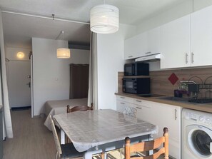 Cocina compacta con microondas, tostadora y lavadora.