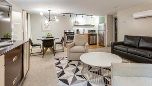 A modern kitchen with a dining area, a sofa, and a coffee table. - Charming Stay for 4 in DT, Walk to Broadway! (Nashville)