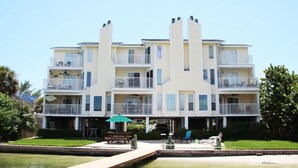 A multi-story hotel with balconies, a dock, and a pool.