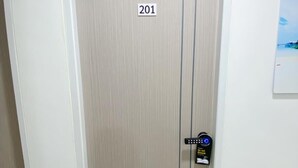 A door with the number 201, a digital lock, and two potted plants on either side. - SJ Beach House Patong (Patong)