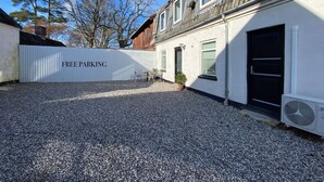Un edificio con fachada blanca, una puerta negra y un letrero que dice "FREE PARKING".