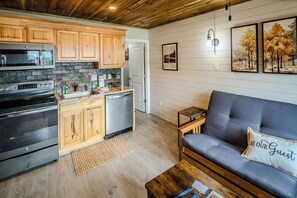 A modern kitchen with wooden cabinets, a built-in oven, and a dishwasher. - Sugar Ski Comfort One Bedroom - Unit 123 (Sugar Mountain)