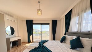 A modern hotel room with a large bed, a desk, and a view of the outdoors.
