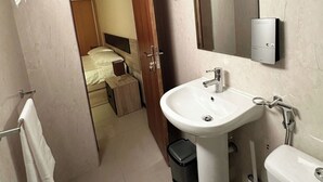 A bathroom with a sink, toilet, and mirror. There is a door leading to a bedroom. - Flat in Praia Plateau (Praia)