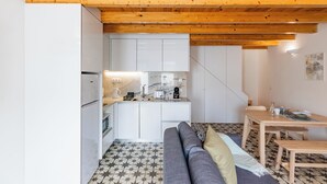 A compact kitchen with white cabinets, a wooden ceiling, and a tiled floor. - A Window to Porto - Pestana Lovely House (Porto)