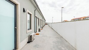 A corridor with a row of air conditioning units and a white wall on one side. - A Window to Porto - Pestana Lovely House (Porto)