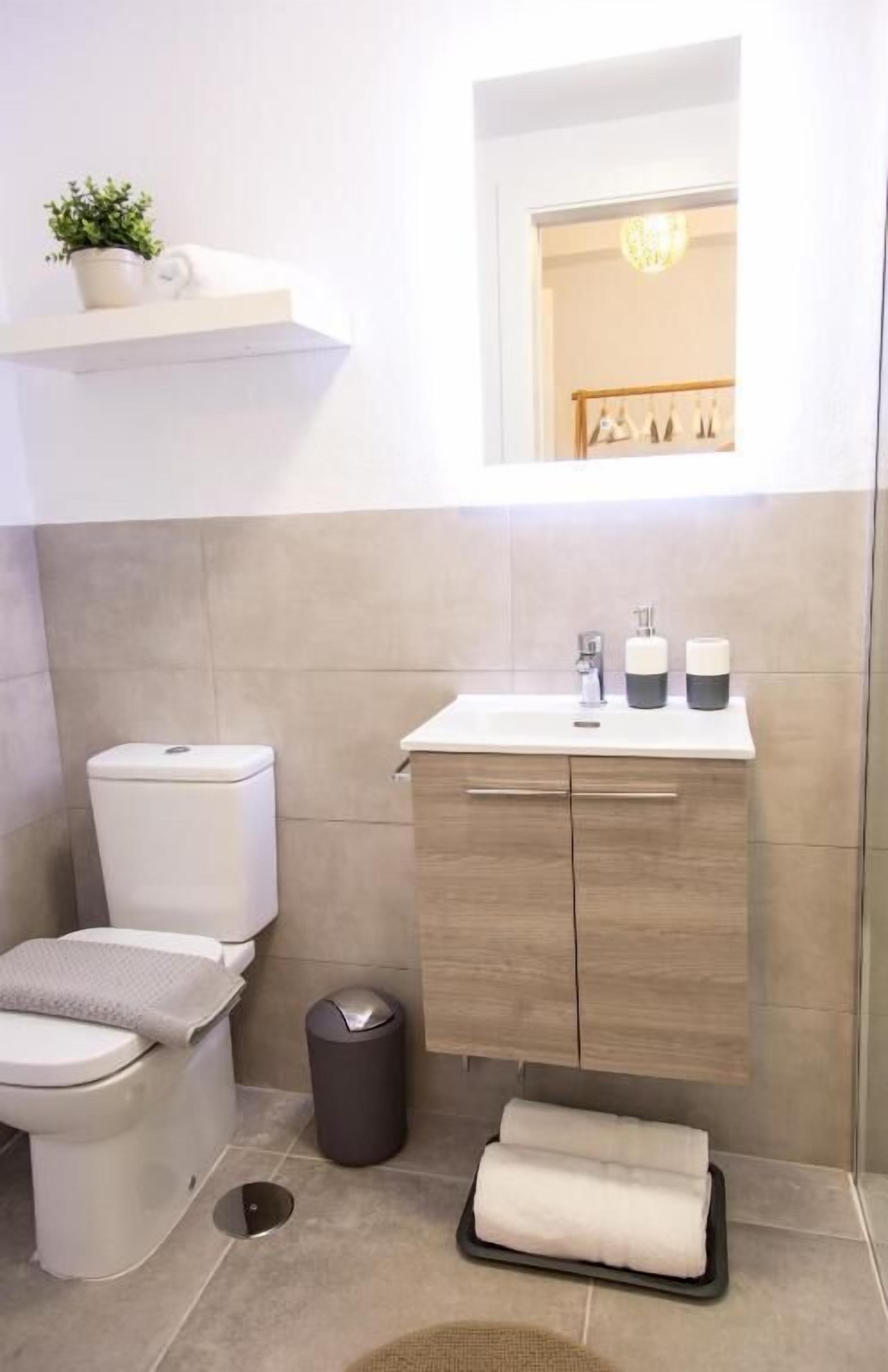Une salle de bain moderne équipée de toilettes, d’un lavabo et d’un meuble-lavabo.