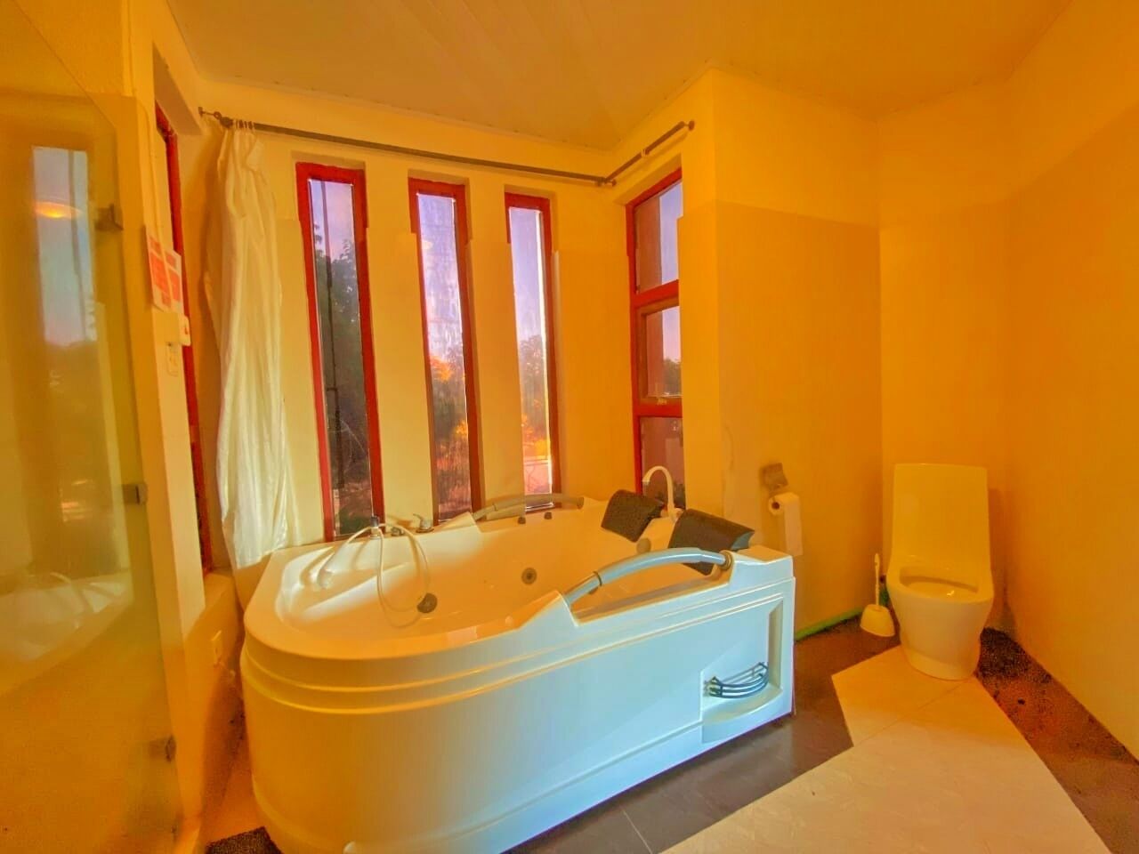 A bathroom with a bathtub, a toilet, and a shower area.